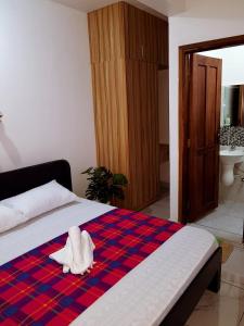 una camera da letto con un letto e un asciugamano bianco di Donita's Seaview Apartments a Mombasa