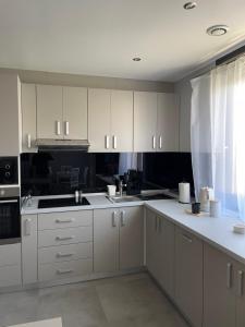 a kitchen with white cabinets and white appliances at Apartment 4 confort&modern in Arad