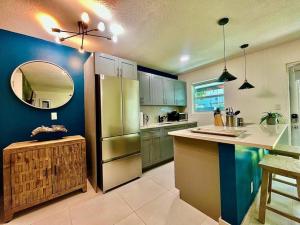a kitchen with a stainless steel refrigerator and a mirror at The Amazon at Holiday Park near Las Olas Beach in Fort Lauderdale