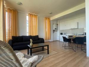 a living room with a couch and a table at NEW Central nr2 Self Checkin OldCity Center Paid Parking with Lift in Timişoara +14 photos