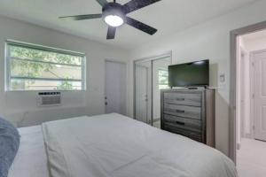 a bedroom with a bed with a ceiling fan and a television at The Amazon at Holiday Park near Las Olas Beach in Fort Lauderdale