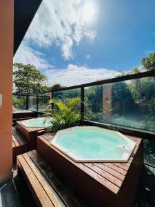 uma banheira de hidromassagem na varanda de uma casa em Flat Partic Hotel Jurere Beach Village em Florianópolis