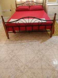 Schlafzimmer mit einem Bett mit roter Bettwäsche und Fliesenboden in der Unterkunft Fitzy Haven in Gros Islet