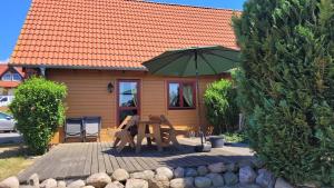 a picnic table with an umbrella in front of a house at Ferienhaus Bliev-Hee Nr 2 in Klink