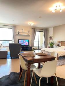 a living room with a table and chairs and a bedroom at Sunset Oasis: Beachfront Studio in Dubai
