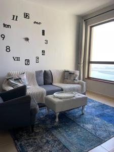 a living room with a couch and a table at Sunset Oasis: Beachfront Studio in Dubai