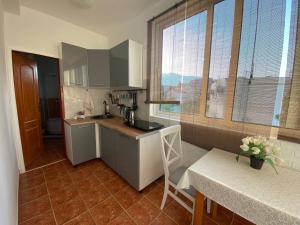 a kitchen with a counter and a table and some windows at Alina's apartment in Bečići