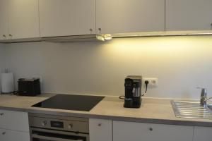 a kitchen with a sink and a counter top at De zwarte deur in Genk