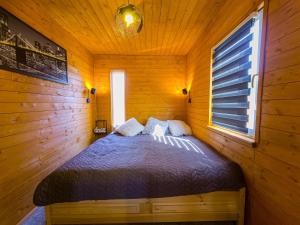 een slaapkamer met een bed in een houten hut bij Cosa Nostra Apartman in Sárvár