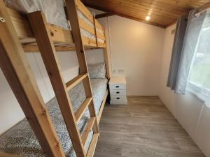 ein Schlafzimmer mit Etagenbetten in einem winzigen Haus in der Unterkunft Cotswold Lodges in Cirencester
