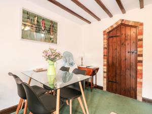 a dining room with a table and chairs and a wooden door at Kathy's Cottage in King's Lynn