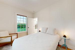 biała sypialnia z łóżkiem i oknem w obiekcie The Lakewood w mieście Swanton