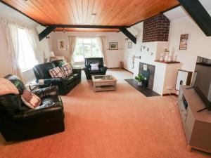 a living room with leather furniture and a fireplace at The Stables in Flemingston