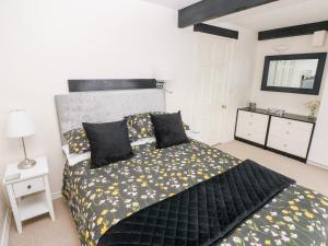 a bedroom with a bed with black and yellow sheets at The Stables in Flemingston