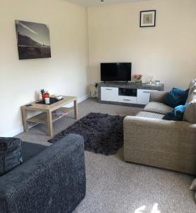 a living room with two couches and a tv at 8 Pickering Road in Telford
