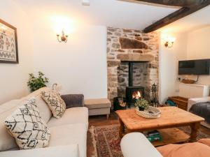a living room with a couch and a fireplace at Hunters Cottage in Bakewell