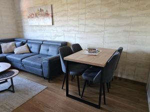 a living room with a table and a couch at Balkan Hill 3 - Apartman TORG in Zlatibor +12 photos