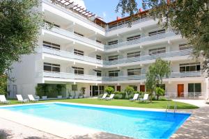 an exterior view of a building with a swimming pool at Corina Suites & Apartments in Limassol