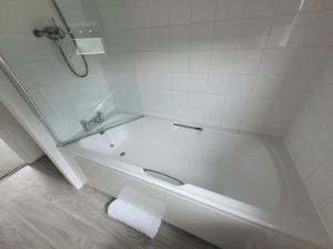 a white bathroom with a tub and a sink at Cotswold Lodges in Cirencester