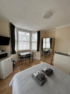 a bedroom with a bed and a table with chairs at WIllesden Lodge Guest House in London