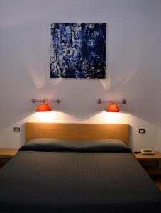 a bedroom with a bed and a night stand at Hotel Cala Luna in Cala Gonone