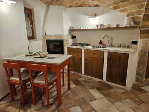 a kitchen with a table and chairs and a sink at DESTASU' Apartments in Castel del Monte