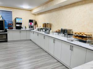 una cocina con armarios blancos y una barra con repostería en The Glengate Hotel & Suites en Niagara Falls