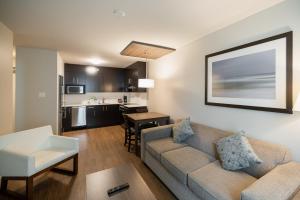 a living room with a couch and a kitchen at Gage Suites at UBC in Vancouver