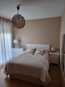 a bedroom with a large bed and a chandelier at Piso acogedor con terraza in Ciudad Real