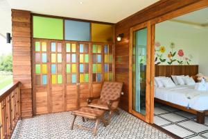 um quarto com uma cama e uma cadeira em แลภู ดูนา LaePhu DooNa Resort and Restaurant em Ban San Pa Sak