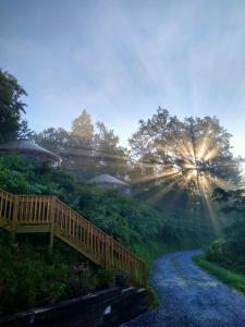 a path leading down a hill with the sun shining at Fontana @ Sky Ridge Yurts in Bryson City