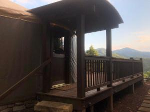 eine Hütte mit einer Terrasse mit Bergblick in der Unterkunft Fontana @ Sky Ridge Yurts in Bryson City