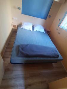 Ce lit se trouve dans une petite chambre dotée d'un matelas bleu. dans l'établissement Camping Tohapi Coeur de Vendée, à La Boissière-de-Montaigu