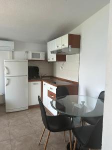 una cucina con tavolo, sedie e frigorifero di Apartments Toni a Trogir