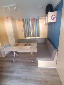Cette petite chambre comprend un lit et une table. dans l'établissement Camping Tohapi Coeur de Vendée, à La Boissière-de-Montaigu