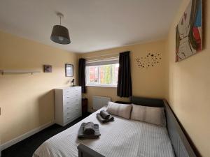 um pequeno quarto com uma cama e uma janela em 3BD Family Stay with a Garden Longbenton Newcastle em Newcastle upon Tyne