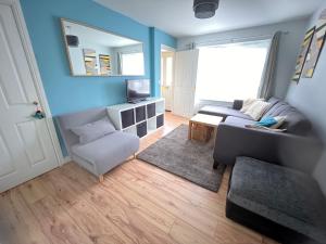 uma sala de estar com um sofá e uma cadeira em 3BD Family Stay with a Garden Longbenton Newcastle em Newcastle upon Tyne