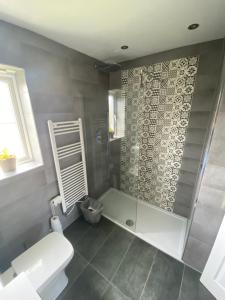 uma casa de banho com um chuveiro, um WC e um lavatório. em 3BD Family Stay with a Garden Longbenton Newcastle em Newcastle upon Tyne