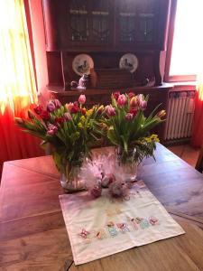 dos jarrones de flores sobre una mesa de madera en Un bell incontro, en Borgo Ticino