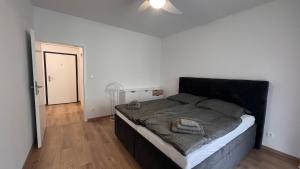 a bedroom with a large bed with a black headboard at 2 room Apartment Rovinka, 204 in Rovinka