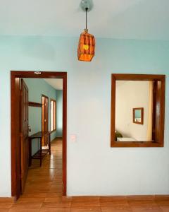 a hallway with a mirror and a pendant light at Pousada Jambrero in Caraíva