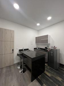 a kitchen with a black counter and a refrigerator at Edificio Lotus Loft in Cali
