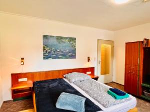 1 dormitorio con 1 cama y una pintura en la pared en Apartment Amelie - Zimmer mit TV, W-Lan, Mikrowelle und Kühlschrank, Bad mit Dusche, en Malterdingen