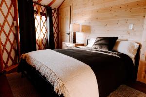a bedroom with a bed in a wooden room at Junaluska @ Sky Ridge Yurts in Bryson City