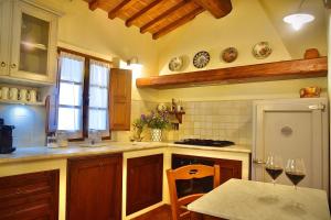 a kitchen with a table and two glasses of wine at Relax in Chianti IL BORGO 8 in Montespertoli