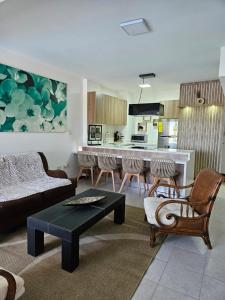 sala de estar con sofá y sillas y cocina en Nautica Beach - Moderno Apartmento Margarita, en Porlamar