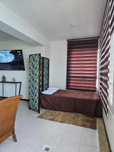 1 dormitorio con cama, ventana y mesa en Nautica Beach - Moderno Apartmento Margarita, en Porlamar