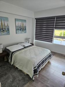a bedroom with a bed and a window with sails at Nautica Beach - Moderno Apartmento Margarita in Porlamar