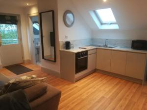 a kitchen and living room with a couch and a sink at Brodleys' Hill Studio 286d in Ballymena