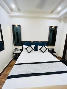 una camera da letto con un grande letto bianco con due finestre di HOTEL Red Rosse a Nuova Delhi